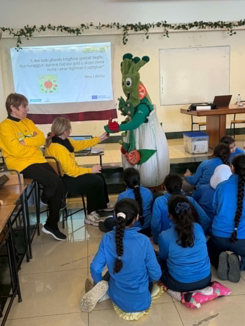 Pupils sitting on the floor watching a costumed character at a visiting workshop